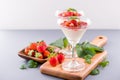 Delicous and nutritious double color colour strawberry desserts with mint and diced sarcocarp topping isolated with airy blue