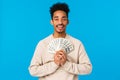 Delight, satisfaction and love concept. Happy and relieved ecstatic african-american guy winning huge money, holding