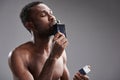 Delighted afro American man smelling his favorite cologne Royalty Free Stock Photo