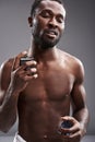 Delighted afro American man using his cologne after shower Royalty Free Stock Photo