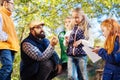 Delighted bearded man sitting in the circle of children