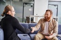 delighted, bearded and tattooed entrepreneur sitting