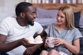 Delighted couple enjoying cupcakes together in bed Royalty Free Stock Photo