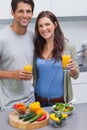 Delighted couple holding glass of orange juice