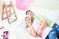 Delighted couple lying on the sofa after painting