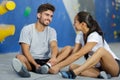 delighted couple sitting in climbing gym