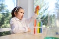 Delighted schoolgirl observes a chemical reaction going in a test tube with colorful reagents and chemicals
