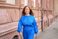 Delighted excited woman walking alongside a commercial building Royalty Free Stock Photo