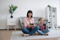 Parent and daughter playing video game with joypads on floor