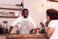 Delighted friendly barista smiling to a client