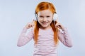 Delighted happy girl pointing at the headphones
