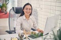 Delighted longhaired woman sitting at her workplace Royalty Free Stock Photo