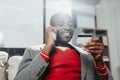 Delighted man chatting by cellphone and examining bankcard