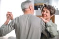 Delighted mature husband and wife dancing in living room Royalty Free Stock Photo
