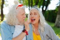 Delighted nice woman biting a strawberry