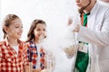 Delighted positive girls being surrounded by chemical smoke