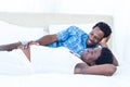 Delighted pregnant woman lying on bed with her husband