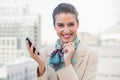 Delighted smart brown haired businesswoman holding a mobile phone