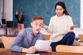 Delighted teenager and Chinese girl schoolmate reading notification