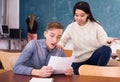 Delighted teenager and Chinese girl schoolmate reading notification Royalty Free Stock Photo