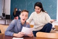 Delighted teenager and Chinese girl schoolmate reading notification