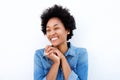 Delighted woman smiling by white wall