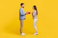 Delighted young man presenting surprise red gift box to excited woman Royalty Free Stock Photo