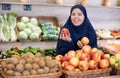 Delighted young Muslim woman purchaser choosing apples in grocery store Royalty Free Stock Photo