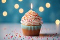 A delightful birthday treat, a cupcake, rests on a light surface