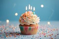 A delightful birthday treat, a cupcake, rests on a light surface