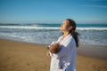 Happy delightful mother carrying her adorable baby boy, walking on the sandy beach on warm sunny day Royalty Free Stock Photo