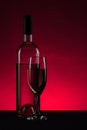 white wine bottle and glass on pink background Royalty Free Stock Photo