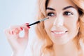 Delightful girl brings eyebrow color with a professional brush. Royalty Free Stock Photo