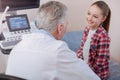 Delightful girl enjoying conversation with practitioner in the hospital