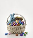 A white basket with full of multicolor candies, jelly beans, bunny blue chocolate, Easter holiday gifts children , generative AI
