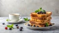 A delightful stack of golden-brown toasted bread slices, adorned with fresh blueberries and a sprig of mint, served alongside a Royalty Free Stock Photo