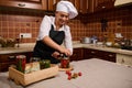 Delightful woman housewife closing lids of jars while canning cherry tomatoes in the home kitchen. Pickling, marinating Royalty Free Stock Photo