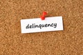 Delinquency. Word written on a piece of paper, cork board background