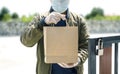 Deliver man wearing face mask with handling paper bag for deliver to customer in the door at home, concept of new normal, corana v Royalty Free Stock Photo
