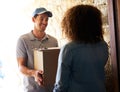 Delivering direct to your door. a courier making a delivery to a customer at her home.