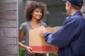 Delivering direct to your door. Shot of a courier making a delivery to a smiling customer.