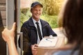 Delivering your goods with a smile. Cropped shot of a young man making a delivery to a woman at her home. Royalty Free Stock Photo