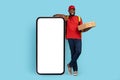 Delivery App. Black Courier Man With Pizza Boxes Standing Near Blank Smartphone Royalty Free Stock Photo