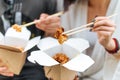 Delivery asian food in boxes, chopsticks in female hands,