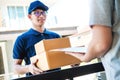 Delivery Asian man service with boxes in hands standing in front of Customer`s house doors