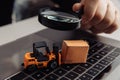 Delivery box, model of loader and a magnifying glass. Concept of internet commerce, online shopping, trade and turnover