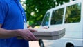 Delivery boy bringing hot tasty pizza, express food delivery, part-time job Royalty Free Stock Photo