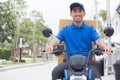 Delivery boy on motorcycle with trunk parcel box driving to fast in rush. Courier delivering order online.