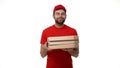 Delivery boy in a red uniform holding a stack of pizza boxes making a home delivery as seen through a spyhole. Shot with