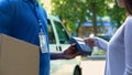 Delivery company client paying by contactless terminal for parcel transporting